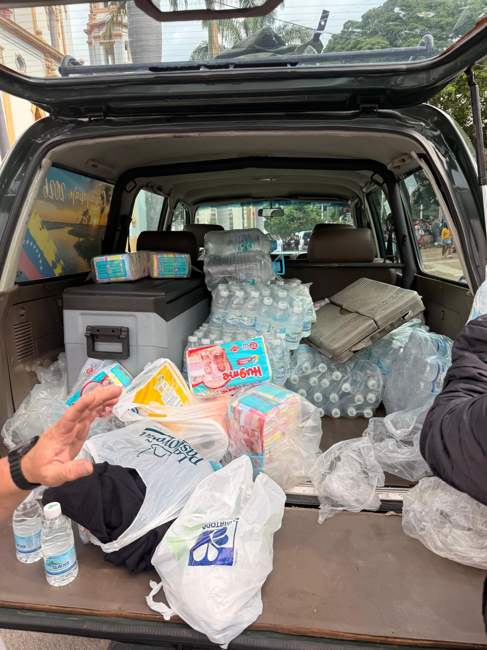 A car loaded with water, diapers and supplies for delivery.