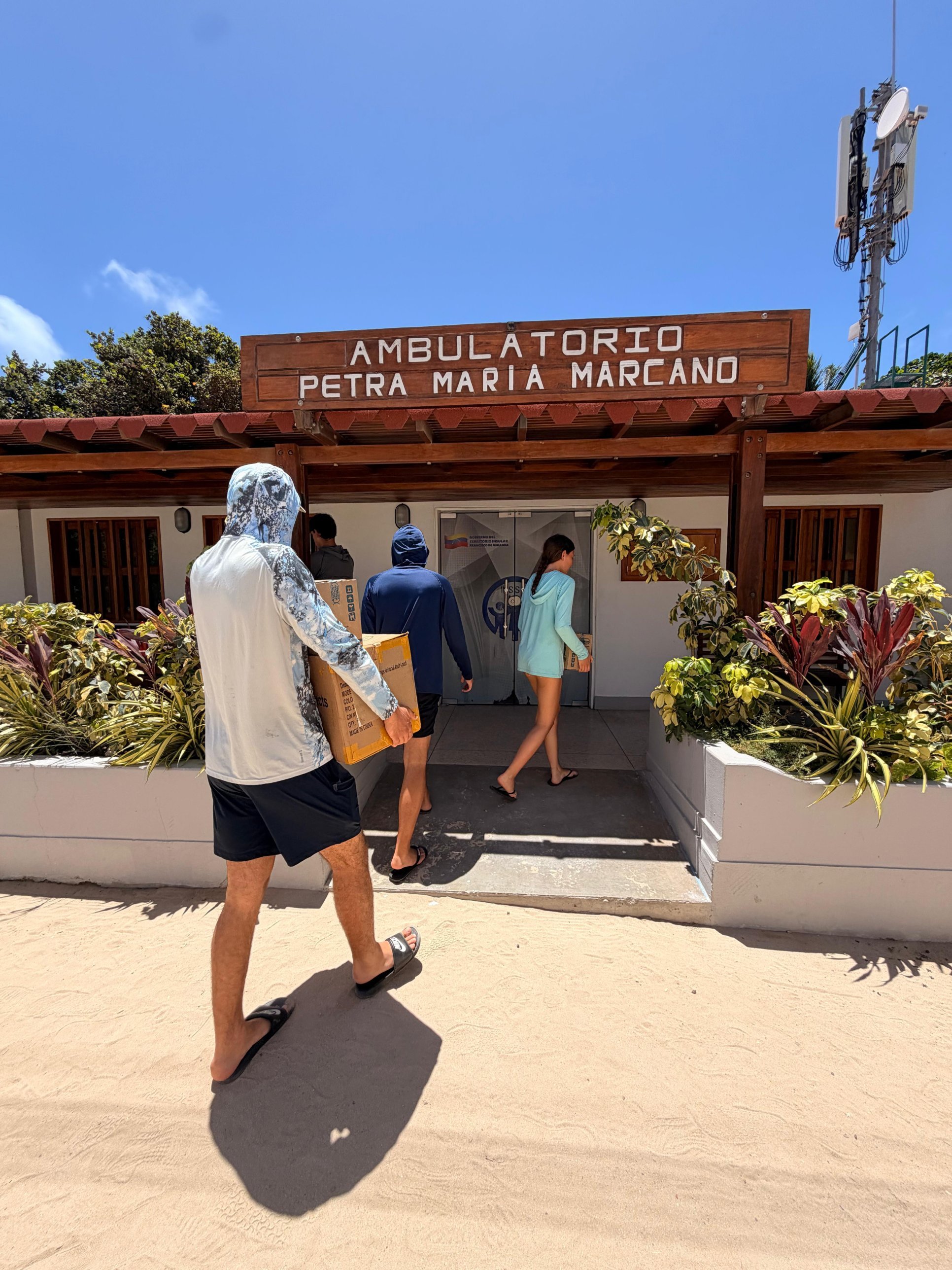 Volunteers carrying boxes of medicine into the Petra María Marcano clinic in Los Roques.